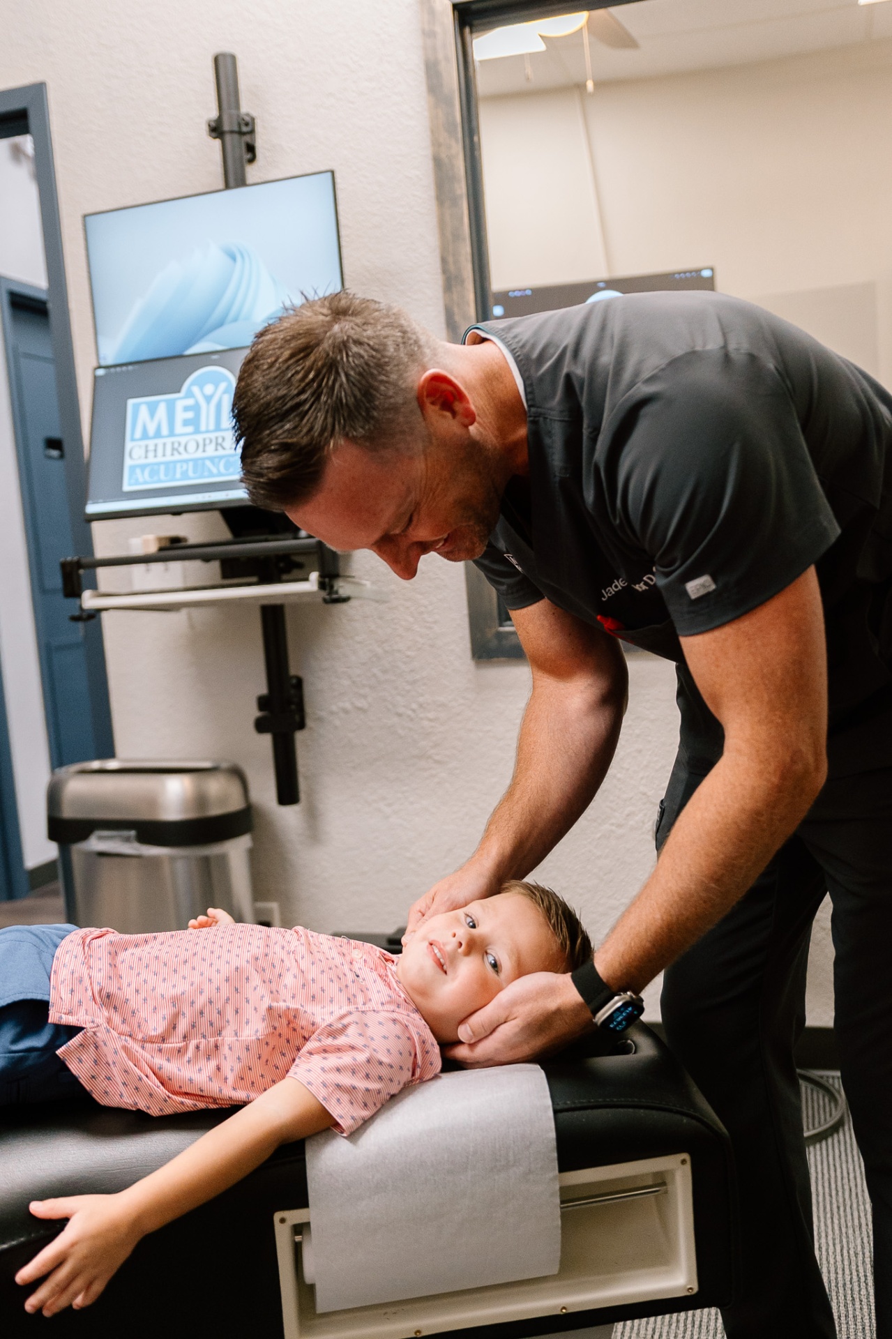 Lenexa chiropractor Dr. Meylor examining young patient for chiropractic adjustment